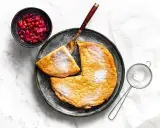 Puszysty omlet z airfryer, posypany cukrem pudrem, podany z żurawiną. Idealny na śniadanie.