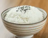Miseczka puszystego ryżu basmati, posypana czarnym sezamem. Idealny przykład, jak ugotować ryż basmati.