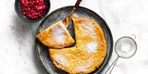 Puszysty omlet z airfryer, posypany cukrem pudrem, podany z żurawiną. Idealny na śniadanie.