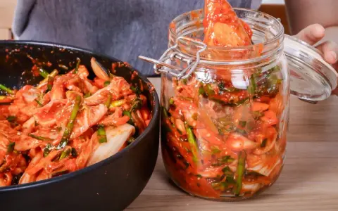 Kimchi w misce i słoiku, gotowe do przechowywania.