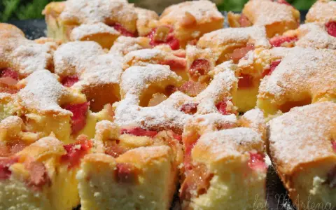 Szybkie ciasto z rabarbarem, posypane cukrem pudrem, wygląda apetycznie. Idealne na letnie popołudnie.