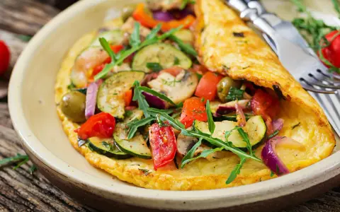 Pyszny omlet dla niemowlaka z cukinią, pomidorkami, oliwkami i rukolą. Zdrowy i kolorowy posiłek.