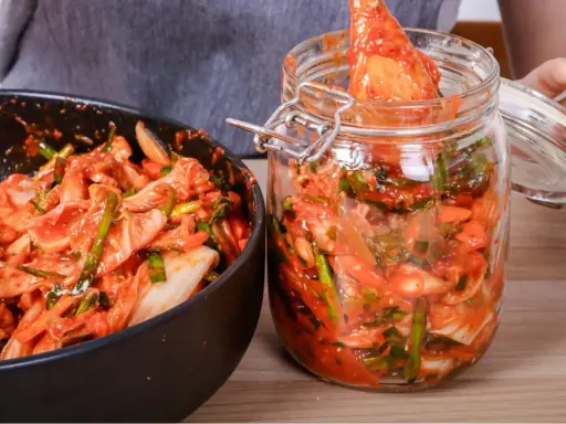 Kimchi w misce i słoiku, gotowe do przechowywania.