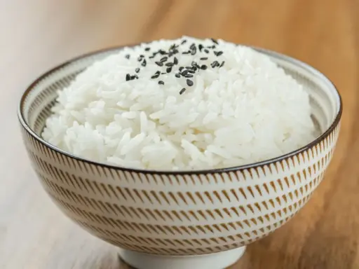 Miseczka puszystego ryżu basmati, posypana czarnym sezamem. Idealny przykład, jak ugotować ryż basmati.