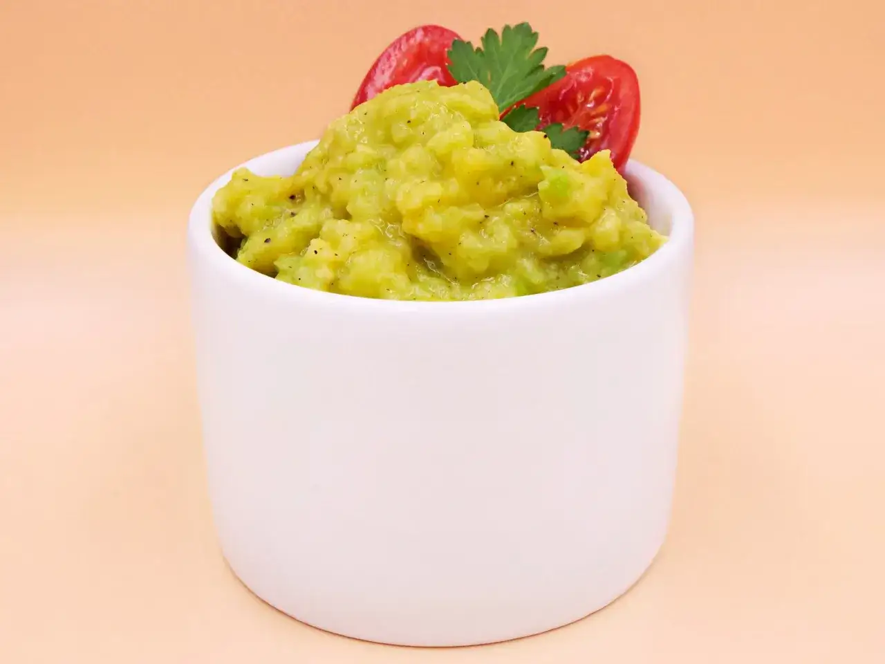 Przekrojone awokado na tle guacamole