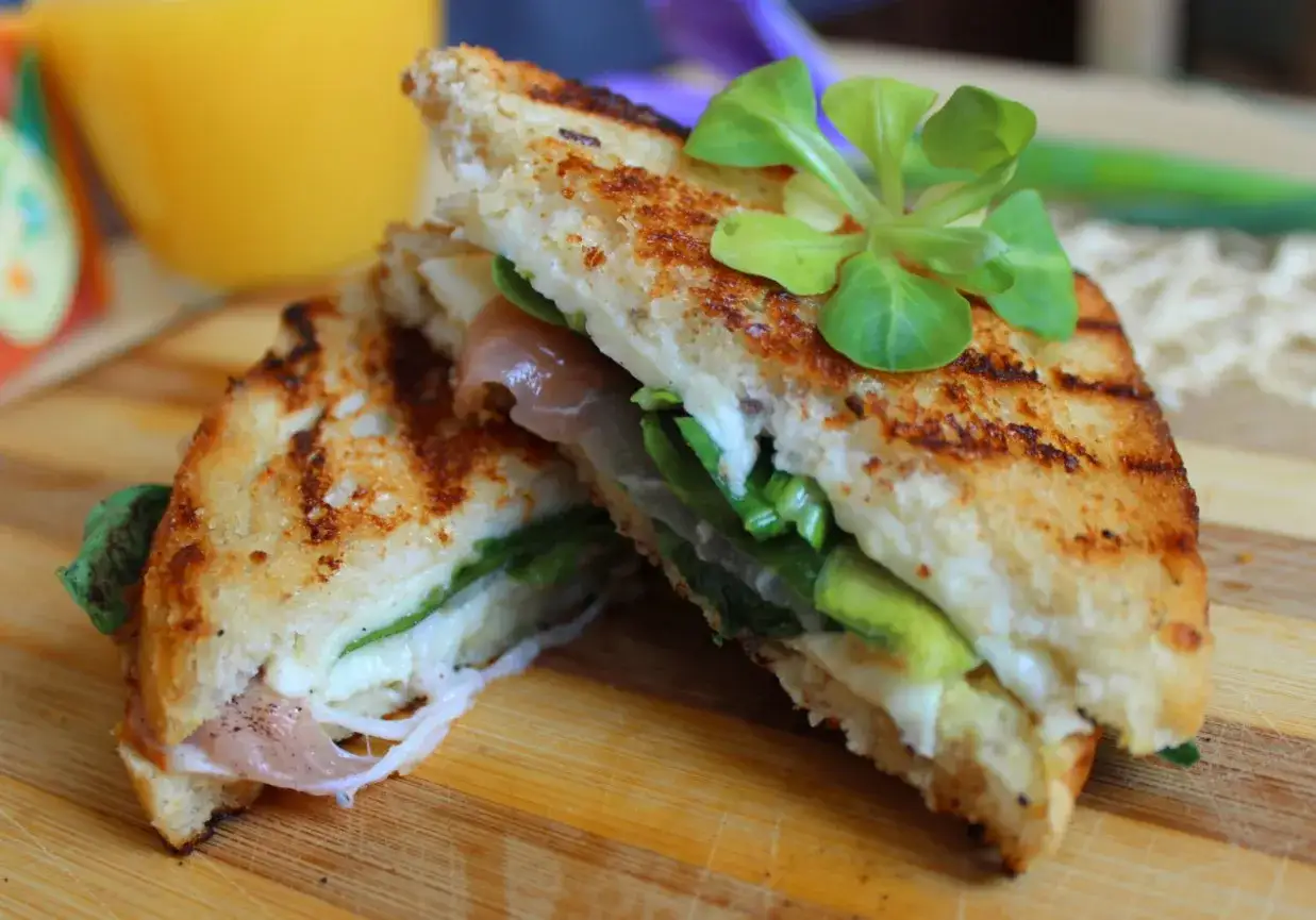 Pyszne, chrupiące panini z szynką, serem i świeżymi ziołami, idealne na szybki lunch.