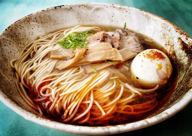 Miseczka aromatycznego ramen co to jest? Makaron, chrupiący bambus, plastry mięsa i jajko na twardo w bulionie.